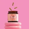 this photo has one tub of ceelabb mushroom capsules, focus blend with a peach label with a friendly mushroom on the label. the photo has a pink background and their are 3 casules falling mid air into the tub.